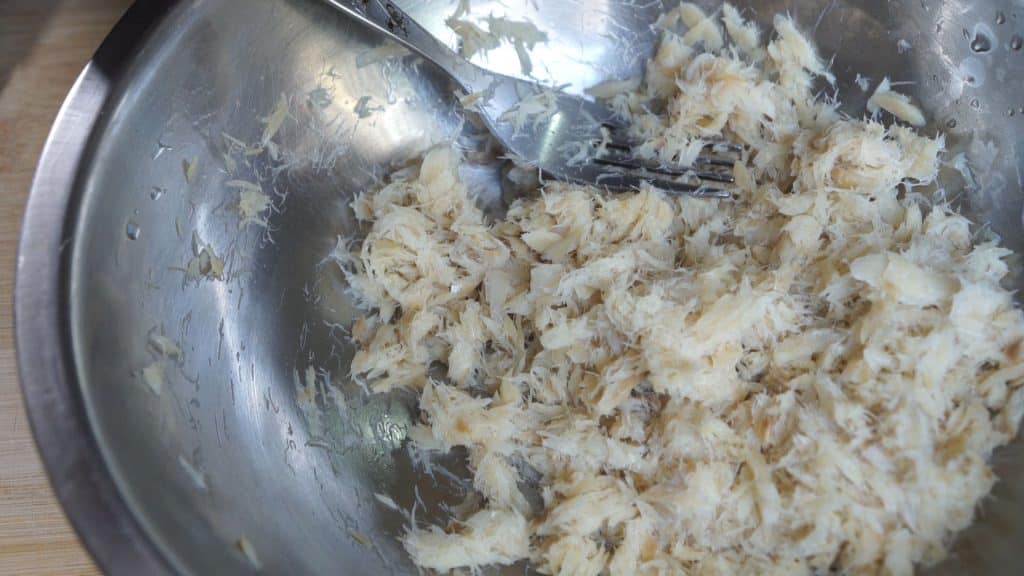 Drain water from saltfish and use a fork to mash or shred it into flakes.